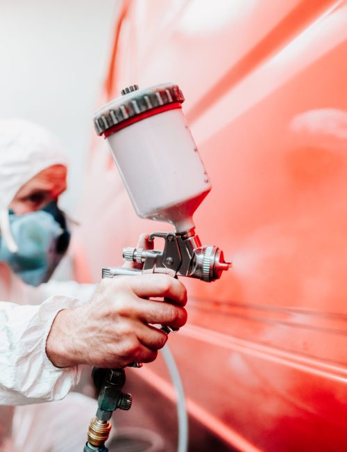 industry details mechanic engineer using spray gun and painting a red car industry details mechanic engineer using spray gun and painting a red car
